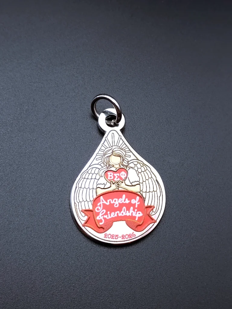 Enamel pin featuring an angel design, created as a commemorative charm for a women’s organization, symbolizing grace, unity, and remembrance.