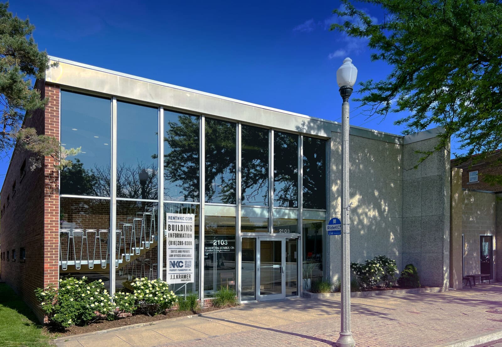 Commercial building with glass facade and outdoor lighting.