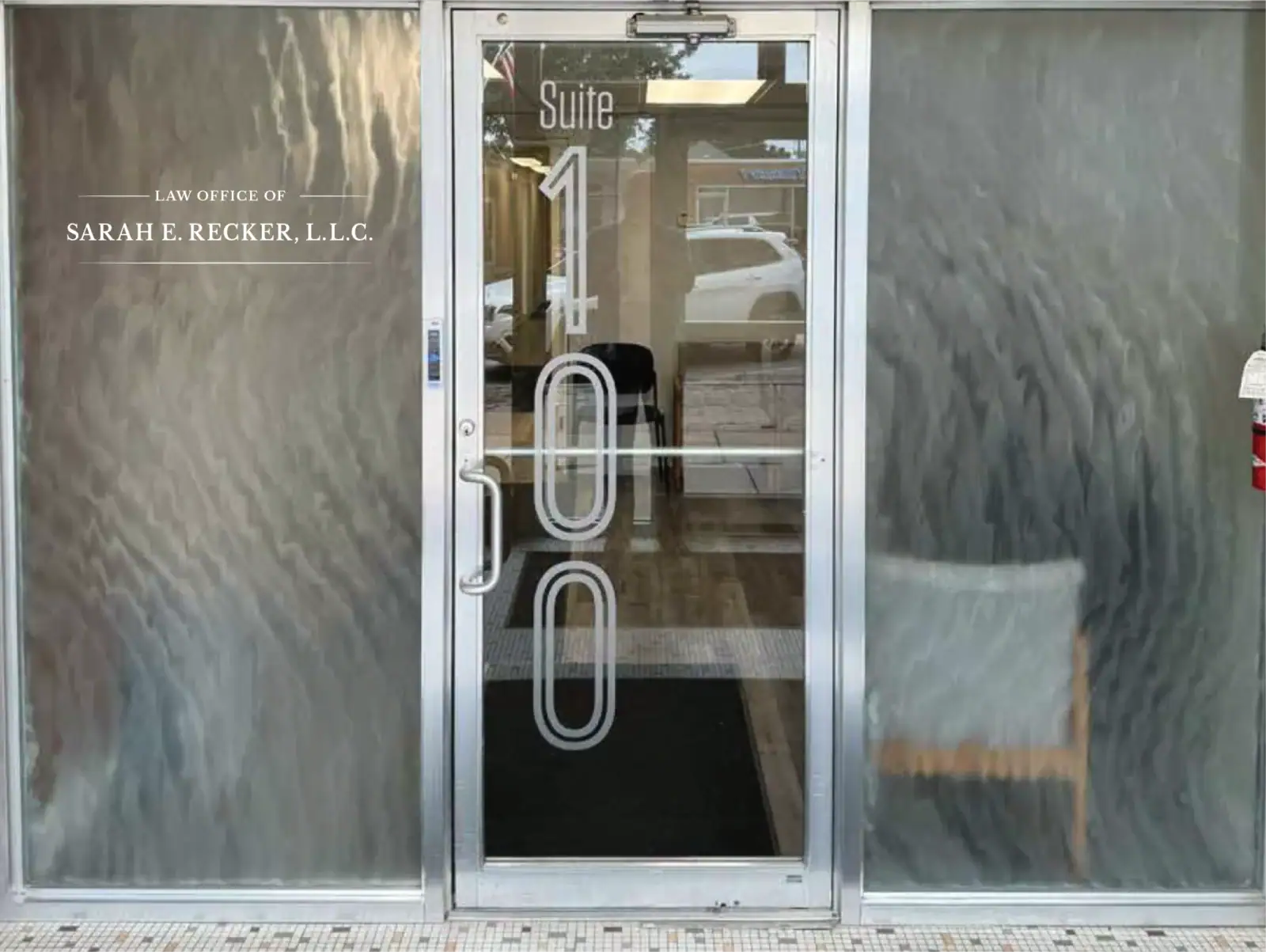 Glass door with suite number and law office signage.