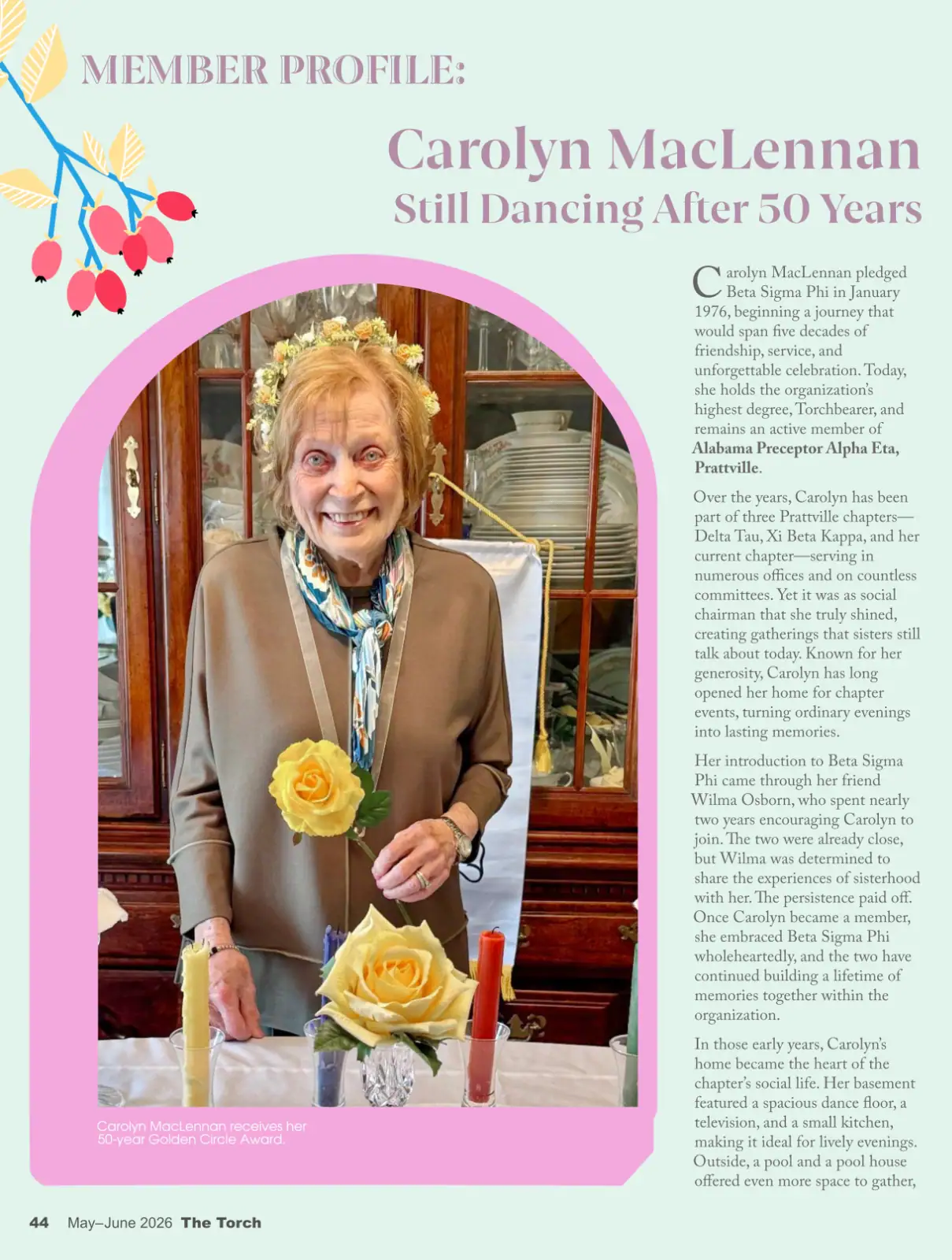 A woman smiling at a celebration with floral decorations and a cake.